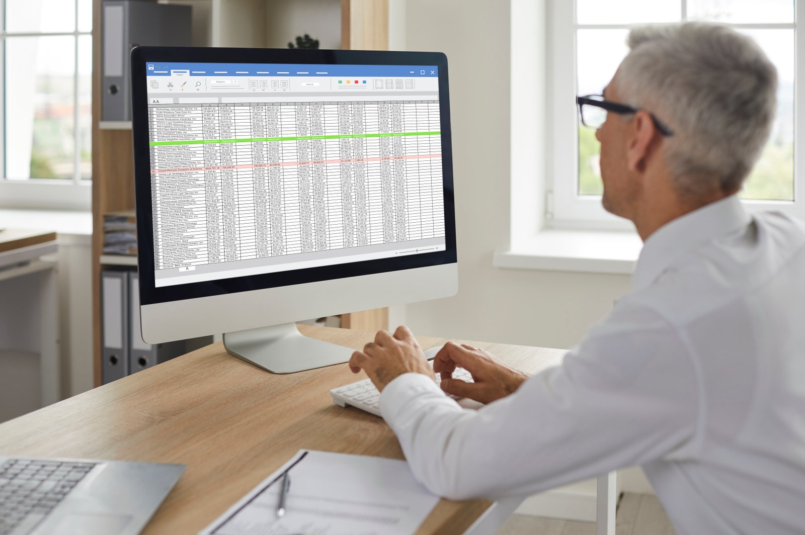 Analyst working with spreadsheets to filter and compare stocks
