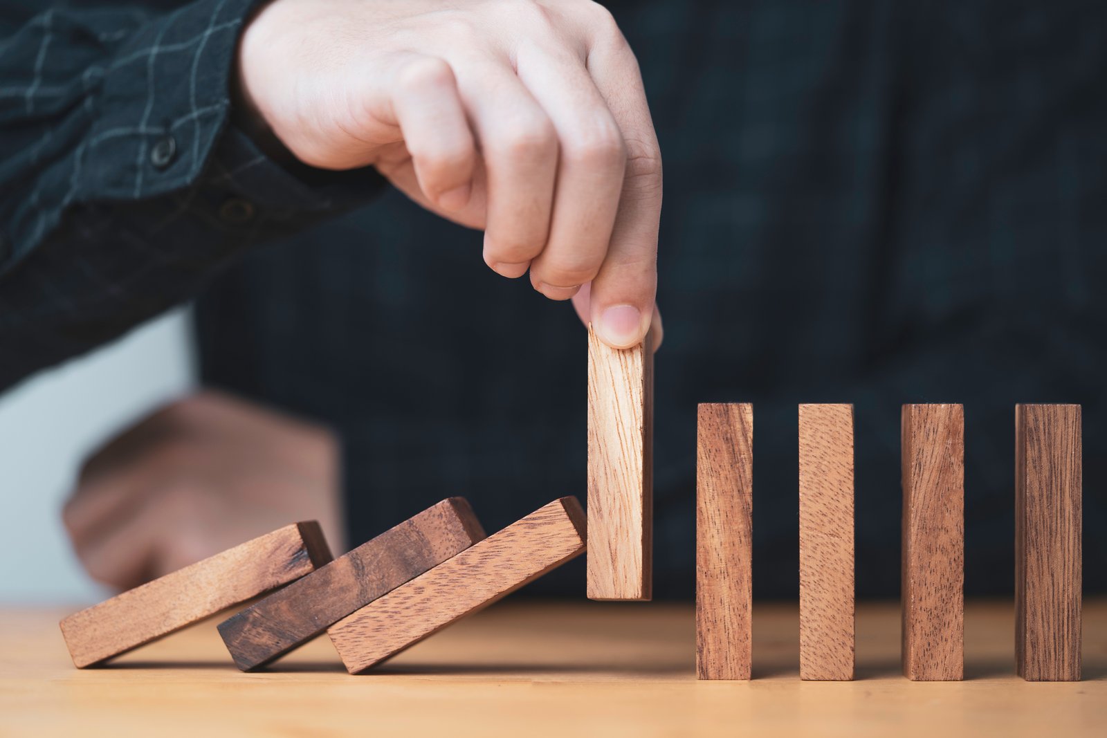 Stop-loss vs limit order: hand stopping a falling domino as a protection concept